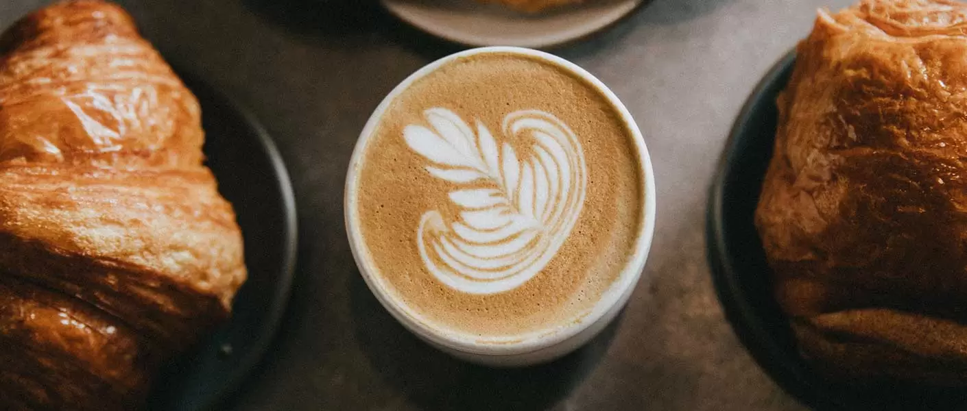 A mushroom pattern in the cream in a mug of coffee in a Needham coffee shop