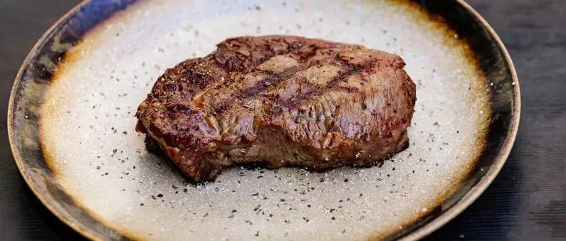 A steak sizzles on the plate in a Kansas City steakhouse
