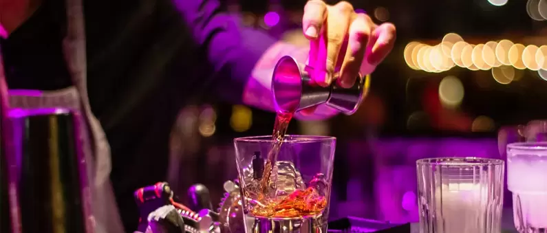 A bartender adds a jigger of liquor to a drink in a Nashville West bar