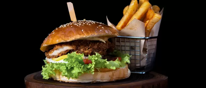 A stacked burger and basket of fries in a Central Atlanta burger joint