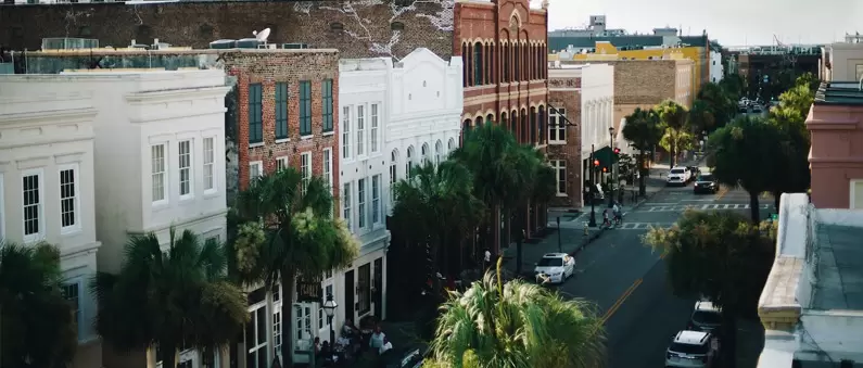 The view from a Charleston hotel shows classic architecture along a tree-line street