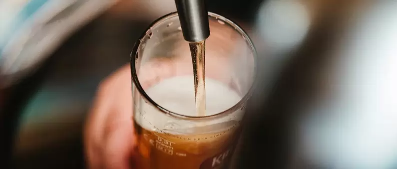 Beer being poured into a glass from a tap in a Pittsburgh pub