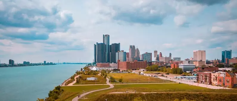 A view of the city skyline across a wide park in Detroit, Michigan